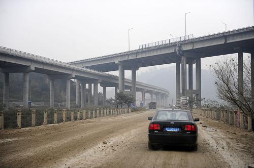 湖北省鄖縣柳陂鎮(zhèn)一處蓄水后將被淹沒的路段上方已經(jīng)架設(shè)了新的橋梁(2012年12月1日攝)。新華社記者 郝同前 攝