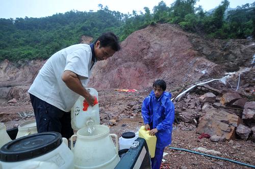 8月23日,在廣西桂平市金田水庫(kù)壩首,該市紫荊鎮(zhèn)居民在接山泉水準(zhǔn)備回家使用。新華社記者 周華 攝