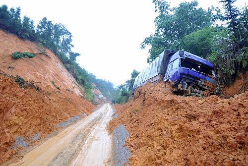 8月23日,一輛被山體滑坡泥石沖壞的汽車仍在剛剛搶通的廣西武平二級(jí)公路邊。新華社記者 周華 攝