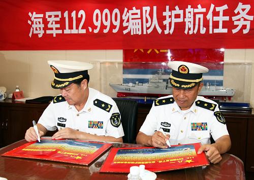 8月22日,在中國海軍第十四批護航編隊哈爾濱艦上,第十四批護航編隊指揮員、北海艦隊副司令員袁譽柏(右)和第十五批護航編隊指揮員、南海艦隊裝備部部長姜中華簽署任務(wù)交接書。新華社記者 梁舜 攝