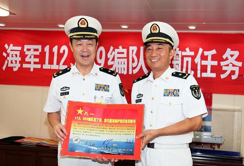 8月22日,在中國海軍第十四批護航編隊哈爾濱艦上,第十四批護航編隊指揮員、北海艦隊副司令員袁譽柏(右)和第十五批護航編隊指揮員、南海艦隊裝備部部長姜中華展示簽好的任務(wù)交接書。新華社記者 梁舜 攝