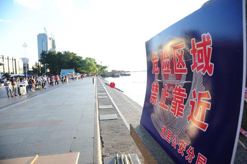 8月23日,松花江哈爾濱市區(qū)段沿江道路拉起警戒線。新華社發(fā)(張清云 攝)