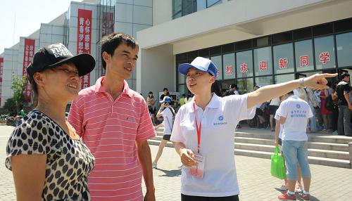 8月24日,一名新生黨員為新生家長(zhǎng)指路。當(dāng)日是華東理工大學(xué)2013級(jí)本科新生的入學(xué)報(bào)到日,41名新生黨員做起為新同學(xué)提供咨詢、指路和搬運(yùn)行李等服務(wù)的迎新志愿者。他們身著印有華東理工大學(xué)“新生黨員勵(lì)志班”的白色T恤,成為校園里一道亮麗的風(fēng)景線。新華社發(fā)(劉曉晶 攝)