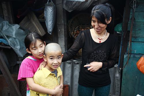 吳霞11歲的女兒和9歲的兒子在他們居住的院內(nèi)玩耍(8月22日攝)。吳霞的家在吉林省通化市二道江區(qū)五道江社區(qū)山源委七組,這里有棚戶近400戶。新華社記者 呂迅 攝