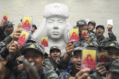 9月14日,在雷鋒紀(jì)念館,新兵們?cè)诶卒h塑像前合影留念。新華社發(fā)(蓋旭輝 攝)