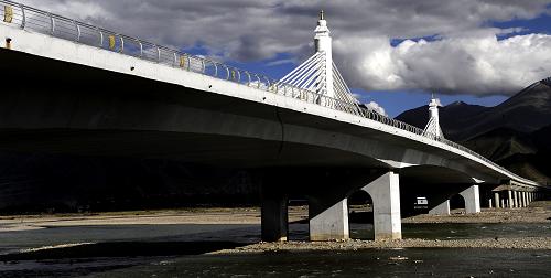 這是9月14日拍攝的即將竣工通車的拉薩納金大橋一角。納金公路大橋被譽(yù)為“拉薩第一橋”,它位于拉薩市東郊,全長1.28公里,橋?qū)?3米,雙向6車道,總投資2.448億元。納金大橋于2011年1月開工,計劃將于2013年10月1日竣工通車。建成后,這座橋?qū)⒗_東區(qū)與318國道連接,進(jìn)一步改善拉薩市區(qū)的交通狀況。目前拉薩河上有三座水泥橋,納金大橋?qū)⒊蔀樽畲?、最寬的公路橋,也是拉薩河上的第四座水泥公路橋。新華社記者 覺果 攝