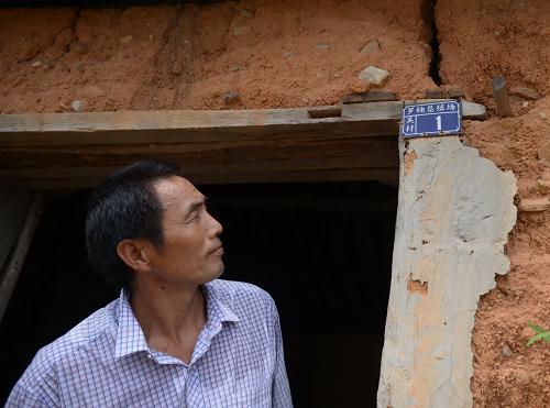晏偉慶回到棚改前居住的村莊里,土墻上的門牌標記著“羅鋪墾殖場吳村1號”(8月30日攝)。新華社記者 周密 攝