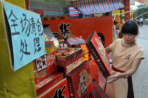 9月17日,在廣西南寧市民族大道,一名女子在“全場清倉處理”的月餅銷售攤前挑選月餅。中秋佳節(jié)臨近,廣西首府南寧市月餅市場卻沒有往年的火爆場面,各大超市“高端大氣上檔次”天價禮盒月餅鮮見其蹤,豪華酒店門口不見了憑票選購月餅的長隊,路邊扎堆“高價收購月餅票”的“黃牛”經(jīng)營慘淡。相反,簡樸包裝、價格實惠、傳統(tǒng)口味的月餅受到市民的普遍歡迎。新華社記者 陸波岸 攝