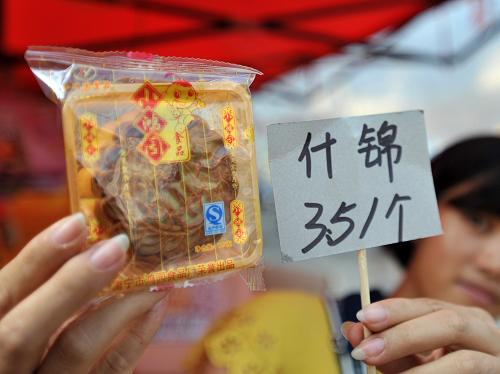 9月17日,在廣西南寧市仙葫大道,一名月餅銷售商在展示簡樸包裝月餅的價格。新華社記者 陸波岸 攝