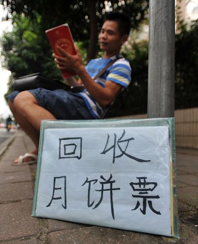 在廣西南寧市金州路,一個“回收月餅票”的人坐在路邊等待生意。新華社記者 陸波岸 攝