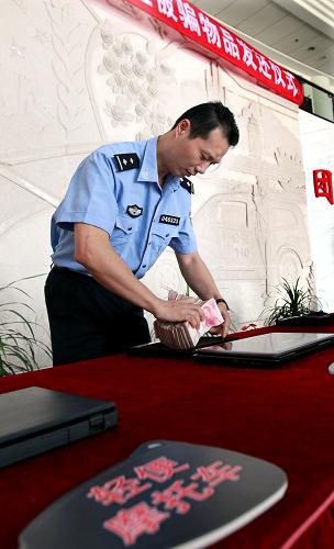 9月17日,民警在發(fā)還儀式現(xiàn)場(chǎng)整理追回的被盜錢(qián)款。新華社記者 凡軍 攝