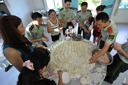 9月18日,云南德宏盈江邊防大隊的官兵和一些遠(yuǎn)道而來的家屬一起包餃子,喜迎中秋。 位于中緬邊境、云南省德宏傣族景頗族自治州盈江縣的邊防官兵常年在邊境線上巡邏執(zhí)勤,一年到頭難得和家人團(tuán)聚。中秋佳節(jié)到來之際,當(dāng)?shù)氐倪叿来箨犔氐嘏e辦“月滿中秋、警營團(tuán)聚”活動,邀請邊防官兵的家屬來到部隊與官兵團(tuán)聚,并與駐地少數(shù)民族群眾聯(lián)歡,共度中秋節(jié)。 新華社記者 藺以光 攝