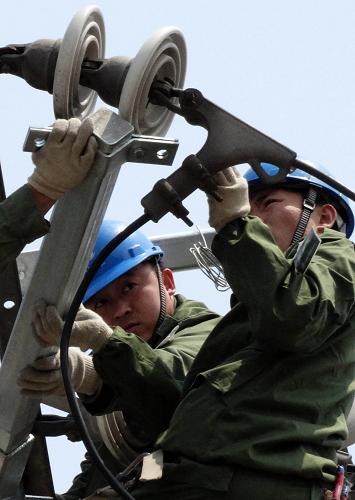 9月28日,國家電網北京朝陽供電公司的技術人員在更換輸電線路的設備。新華社記者 李欣 攝