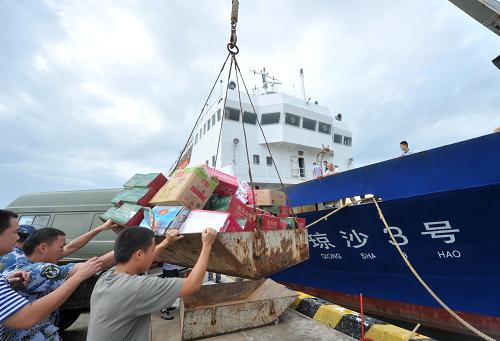 10月3日,從海南文昌運往三沙永興島的第一批救災(zāi)物資已抵達(dá)三沙。強臺風(fēng)“蝴蝶”給三沙市造成了嚴(yán)重經(jīng)濟(jì)損失。據(jù)三沙市經(jīng)濟(jì)發(fā)展局統(tǒng)計,強臺風(fēng)“蝴蝶”襲擊共造成三沙市103間房屋倒塌,101間房屋受到不同程度的損壞,同時80余艘大小船只遭受到了碰撞、擱淺、沉沒等損失。各島礁多個工地施工設(shè)備以及多家單位重要儀器受損。西沙群島海域的深水網(wǎng)箱養(yǎng)殖基地約140口深水網(wǎng)箱損壞,損失各種珍貴魚類約360噸,琛航島海底光纜同時也嚴(yán)重受損斷裂。在首批救災(zāi)物資抵達(dá)后,第二批救援物資將于10月5日運往三沙市。新華社記者 趙穎全 攝