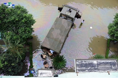 10月10日,浙江余姚鳳山街道工作人員與南京軍區(qū)救災(zāi)官兵一起,涉水將150多箱餅干和41箱水緊急運(yùn)送到被積水圍困的劍江村大葉園林公司600多位外來務(wù)工人員手中。由臺風(fēng)“菲特”導(dǎo)致的降水致浙江余姚城區(qū)大面積被淹,部分區(qū)域停電停水,目前城區(qū)積水仍未退去。當(dāng)?shù)卣⒕葹?zāi)官兵以及民眾全力開展搶險(xiǎn)救災(zāi)工作。新華社記者 鞠煥宗 攝 10月10日,浙江余姚鳳山街