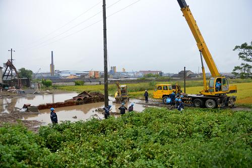 10月8日,浙江省嘉善縣供電公司的工作人員在農(nóng)田里搶修受損線路。臺(tái)風(fēng)“菲特”過(guò)后,浙江省嘉善縣大面積農(nóng)田被淹,多條電力線路受損。嘉善縣供電公司迅速派出各路精兵強(qiáng)將,冒雨趕赴受災(zāi)現(xiàn)場(chǎng)搶修線路。目前,受災(zāi)線路已恢復(fù)供電,被淹農(nóng)田陸續(xù)完成排澇。新華社發(fā) (張敏 攝)