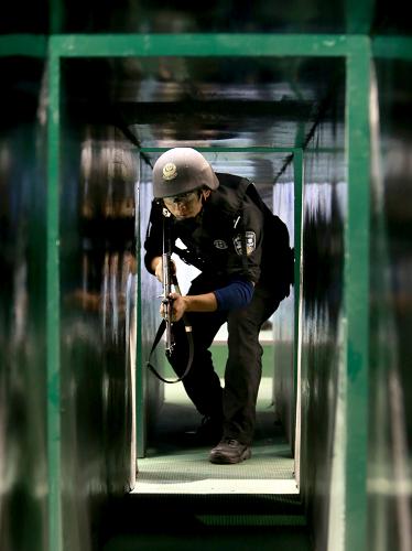 10月18日,在中部四省公安特警“大比武”中,一名特警隊(duì)員參加射擊技能科目中“單兵出擊”項(xiàng)目的比賽。新華社發(fā)(劉書亭 攝)
