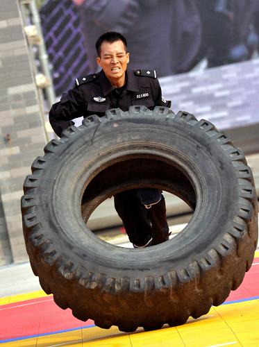 10月18日,在中部四省公安特警“大比武”中,一名特警隊(duì)員參加綜合體技能科目中“翻滾輪胎”項(xiàng)目的比賽。新華社發(fā)(劉書亭 攝)