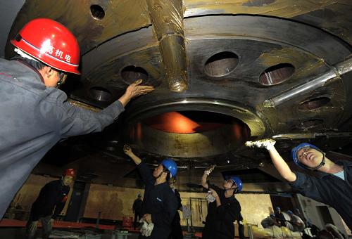 10月19日,工作人員對吊出的葛洲壩大江電廠15號機(jī)組重達(dá)600噸的轉(zhuǎn)子進(jìn)行維護(hù)工作。新華社記者 肖藝九 攝