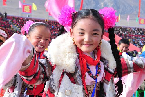 11月3日,玉樹第二完全小學三年級學生才仁永藏(右)在玉樹各族群眾慶祝災后重建竣工大會上揮舞哈達。