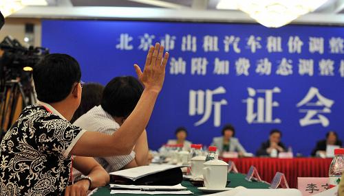 一位聽證會(huì)參加人在北京舉行出租汽車租價(jià)調(diào)整和完善燃油附加費(fèi)動(dòng)態(tài)調(diào)整機(jī)制聽證會(huì)上舉手要求發(fā)言(2013年5月23日攝)。新華社記者 李文 攝
