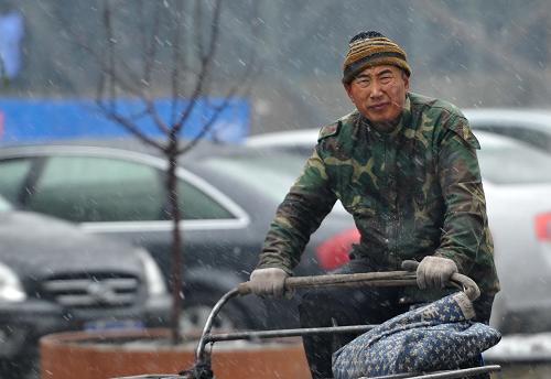 11月16日,吉林省長(zhǎng)春市,市民冒雪騎車(chē)出行。新華社記者 張楠 攝