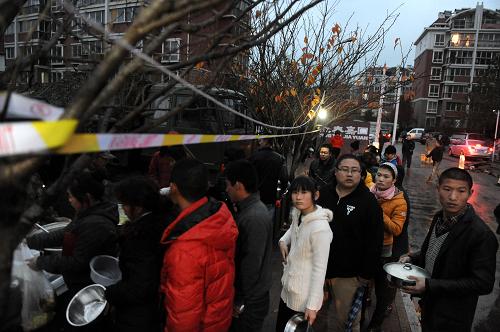 11月24日,黃島劉公島路盈泰嘉園社區(qū)居民在愛民便民服務(wù)點排隊領(lǐng)取晚餐。新華社記者 李紫恒 攝