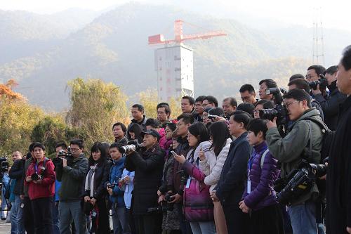 12月1日,參加嫦娥三號(hào)發(fā)射任務(wù)報(bào)道的記者在發(fā)射場(chǎng)聽(tīng)取情況介紹。當(dāng)日,嫦娥三號(hào)月球探測(cè)器的發(fā)射進(jìn)入最后準(zhǔn)備階段。在西昌衛(wèi)星發(fā)射中心,灰色的發(fā)射塔已經(jīng)將運(yùn)載火箭和探測(cè)器完全包裹起來(lái)。目前,發(fā)射時(shí)間仍然定在2日凌晨1點(diǎn)半。新華社記者 王建民 攝