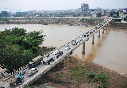 這是寧明縣城居民唯一的過往通道——寧明橋,每天都要承載輕重車輛與百姓通行的重任。在廣西寧明縣城,有一座橫跨明江兩岸的老橋,當(dāng)?shù)厝朔Q“寧明橋”,始建于1965年,上世紀(jì)90年代以來,這座老橋頻繁遭受重車碾壓,不堪重負(fù),寧明縣公路局已將其核定為危橋,其承載能力只有10噸。但如今這座老橋仍在超負(fù)荷運(yùn)營,橋基多處出現(xiàn)裂縫,重車駛過時(shí),橋面上下劇烈抖動(dòng),令過往行人膽戰(zhàn)心驚。寧明縣黨委、政府多次打報(bào)告想爭取在比鄰這座橋處建一座新橋,但上級有關(guān)部門認(rèn)為明江是一條水上通道而不予審批。據(jù)當(dāng)?shù)厝罕姺从?,走明江水路到南寧?60多公里,而走陸路只有100多公里。新華社記者 張愛林 攝