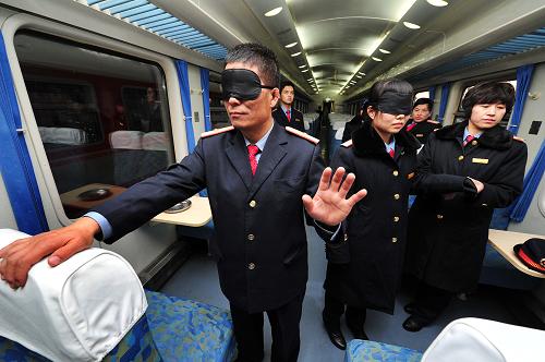 12月3日,在銀川火車(chē)站一趟列車(chē)上,幾位列車(chē)乘務(wù)員在體驗(yàn)盲人行走。新華社記者 彭昭之 攝