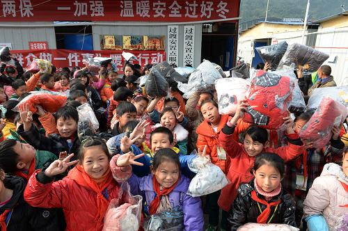 12月5日,在四川省雅安市寶興縣靈關鎮(zhèn)趙家壩集中過渡安置點,寶興縣靈關鎮(zhèn)中心小學的學生展示領取到的棉衣。新華社發(fā)(李向雨 攝)