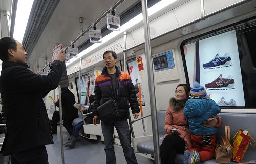 12月28日,乘客在鄭州地鐵列車內(nèi)拍照留念。新華社記者 趙鵬 攝