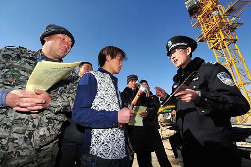 12月30日,在寧夏銀川市一處工地上,鐵路公安處的民警在向務(wù)工人員介紹返鄉(xiāng)期間禁止攜帶上車的各類工具。新華社記者 彭昭之 攝