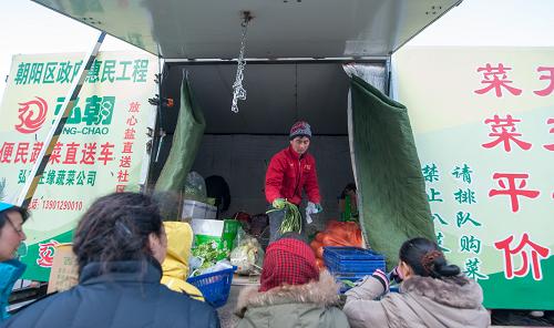 2013年12月31日,居民在北京市朝陽(yáng)區(qū)望京北路上的弘朝便民蔬菜售賣車前買菜。售賣車每周二、五上午都會(huì)攜帶百余種蔬菜和水果在此處售賣。2013年,北京市朝陽(yáng)區(qū)陸續(xù)新建、改造各類蔬菜零售終端45家,其中社區(qū)菜市場(chǎng)(農(nóng)貿(mào)市場(chǎng))7家,社區(qū)便民菜店14家,超市搭載蔬菜銷售14家,流動(dòng)蔬菜售賣車10臺(tái),緩解百姓買菜難、買菜貴的問(wèn)題。新華社記者 張宇 攝