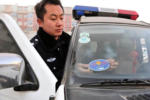 2013年12月31日,在山西省臨汾市隰縣公安局大院工作人員對警車張貼“公務(wù)車”統(tǒng)一標(biāo)識(shí)。新華社發(fā)(李虎威 攝)