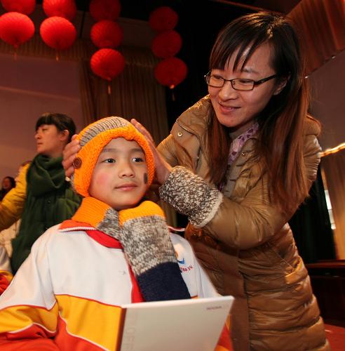 12月31日,“社會(huì)媽媽”給山東省文登市實(shí)驗(yàn)小學(xué)留守、流動(dòng)兒童送來保暖衣物。新華社發(fā)(陳宏青 攝)