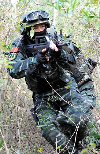 1月7日,武警特戰(zhàn)隊(duì)員交替掩護(hù),在灌木叢中搜索前進(jìn)。當(dāng)日,廈門武警特戰(zhàn)隊(duì)在福建省廈門市舉行代號(hào)為“2014-西岸鳴鏑”的山林地反恐實(shí)戰(zhàn)演練,對(duì)實(shí)施“恐怖”活動(dòng)、逃匿于復(fù)雜山林地帶的“恐怖分子”進(jìn)行封控、搜索和捕殲,錘煉特戰(zhàn)隊(duì)員實(shí)戰(zhàn)能力。新華社記者 彭張青 攝