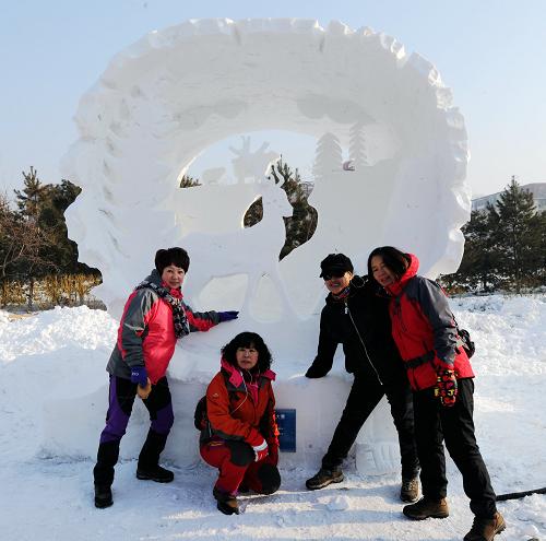 1月7日,幾位游客在獲得一等獎的哈爾濱工程大學(xué)的雪雕作品《動物博物館》前合影。當(dāng)日,以“靈動·雪之夢”為主題的2014年第六屆國際大學(xué)生雪雕大賽在哈爾濱工程大學(xué)落下帷幕。來自中國、俄羅斯、英國、日本、朝鮮、泰國、馬來西亞、丹麥、韓國等11個國家和地區(qū)的61支參賽隊(duì)參賽。大學(xué)生們在4天的時間里用無限的創(chuàng)意、手中的鐵鏟、團(tuán)隊(duì)的合作同臺切磋雪雕技藝、釋放自己的青春能量和冰雪夢想。新華社記者 王松 攝