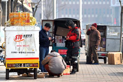 1月10日,三名快遞員將電動(dòng)三輪車(chē)??吭谌诵械郎纤拓洝=?,天津市政府辦公廳轉(zhuǎn)發(fā)了市發(fā)展改革委《關(guān)于促進(jìn)快遞服務(wù)業(yè)發(fā)展的意見(jiàn)》。該意見(jiàn)要求,完善新能源汽車(chē)充電等配套基礎(chǔ)設(shè)施,優(yōu)先將快遞企業(yè)購(gòu)置新能源汽車(chē)納入推廣范圍,爭(zhēng)取中央財(cái)政補(bǔ)貼資金支持。按照全市統(tǒng)一部署,將快遞電動(dòng)三輪車(chē)統(tǒng)一更新為輕、微型封閉式貨車(chē)。新華社記者 岳月偉 攝