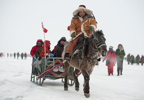 1月18日,游客們在烏倫古湖的冰面乘坐馬拉雪橇。新華社記者 江文耀 攝
