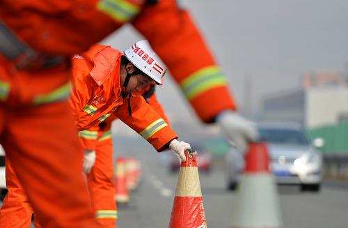 1月26日,甘肅天水高速清障救援一大隊隊員馮佳翱正在高速公路上設(shè)置安全錐。為保障春運期間高速公路暢通和行車安全,甘肅省高速公路管理局所轄的各高速清障救援大隊均放棄了節(jié)假日休息,隊員們堅守一線,在甘肅省內(nèi)3000多公里的高速公路上全天候巡查,為“平安春運”保駕護航。新華社記者 陳斌 攝