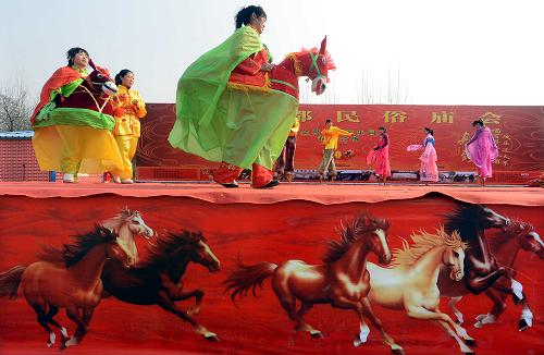 1月26日,民間藝人在露天舞臺上表演傳統(tǒng)社火。當日,2014鄭州商都民俗廟會在鄭州金鷺鴕鳥園景區(qū)開幕。本屆廟會以“文化中原、歡樂中原、美麗中原”為主題,將春節(jié)禮儀展示、春節(jié)習(xí)俗體驗、春節(jié)社火表演等原汁原味地搬到廟會現(xiàn)場,為市民和游客打造一個具有中原特色的年俗文化大舞臺。新華社記者 王頌 攝
