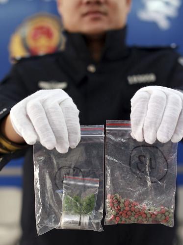 1月26日,武漢鐵路民警展示收繳的毒品。當日,武漢鐵路警方宣布成功破獲一起公安部毒品目標案件。2013年6月,武漢鐵路公安局從前期破獲的一起毒品案的審查中獲取一條重要線索。經(jīng)過半年多的縝密偵查,武漢警方于日前打掉一個從湖南向武漢販運冰毒、麻果等毒品的特大跨省販毒團伙。警方共抓獲團伙成員12名,繳獲麻果、冰毒2.28公斤,收繳毒資97.5萬元。新華社發(fā)(趙軍 攝)