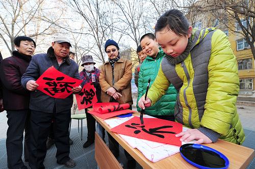 1月26日,在寧夏銀川新華街道永安社區(qū)內,銀川市青少年宮的孩子在為居民寫“福”字。臨近春節(jié),寧夏銀川市青少年宮舉行“新春送福”活動。剛放寒假的孩子們在老師的帶領下來到市內多個社區(qū),親手寫下“福”字,并贈送給社區(qū)居民,向他們送去新春祝福。新華社記者 彭昭之 攝