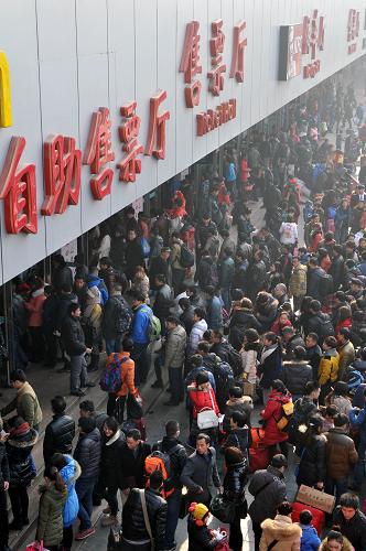 1月25日,在鄭州長途汽車中心站售票廳,眾多旅客在排隊(duì)買票。新華社記者 李博 攝