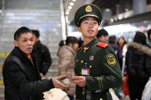 1月30日,武警浙江總隊直屬支隊的武警戰(zhàn)士在杭州鐵路東站為旅客指路。新華社發(fā)(郭廣杰 攝)