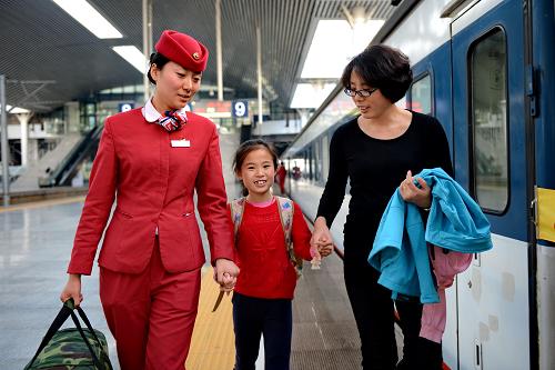 1月30日,乘務(wù)員朱建歡(左)在送一對(duì)母女上車(chē)。工作4年的她,已在車(chē)廂里度過(guò)了3個(gè)除夕夜。新華社記者 張國(guó)俊 攝
