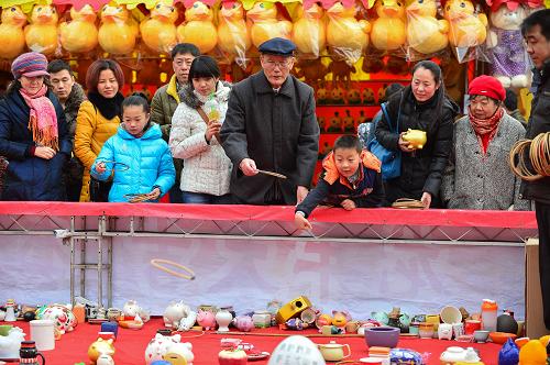 1月31日,在第十九屆北京大觀園紅樓廟會(huì)上,市民、游客在玩套圈游戲。新華社記者 李鑫 攝
