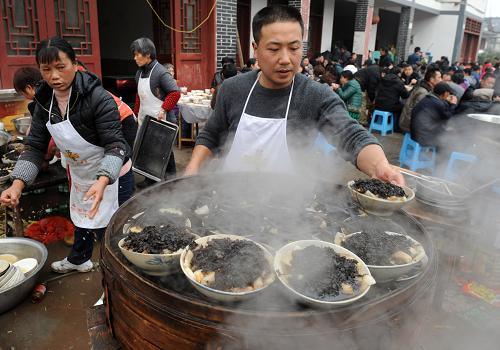 2月2日,在重慶市大足區(qū)寶頂鎮(zhèn)通遠村,“壩壩席”的廚師正在忙碌。新華社記者 李斌 攝