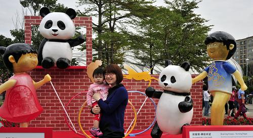 2月2日,游人在圓仔主題景觀造型前拍照。春節(jié)期間,臺北花博公園推出“圓仔迎春 三戲牡丹”花畫聯(lián)展,并為即將舉行的元宵燈節(jié)設(shè)置以大熊貓圓仔為主題的“懷舊童玩燈區(qū)”,吸引眾多市民前來觀賞。新華社發(fā)(吳景騰 攝)